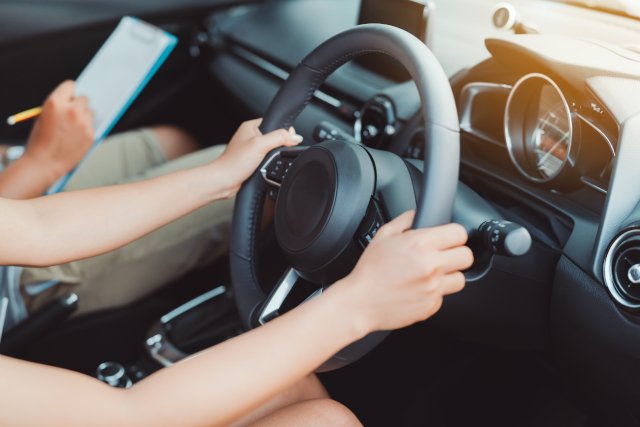 person having an in-car driving lesson